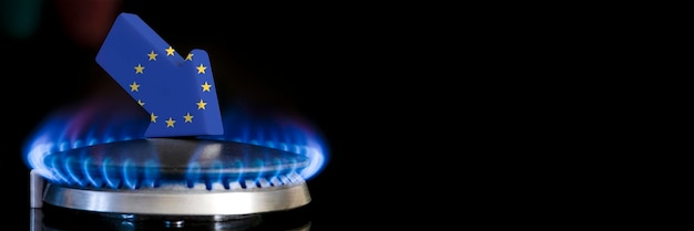 Diminuzione delle forniture di gas nell'unione europea una stufa a gas con una fiamma che brucia e una freccia con i colori della bandiera dell'unione europea rivolta verso il basso concetto di crisi in inverno e mancanza di gas naturale