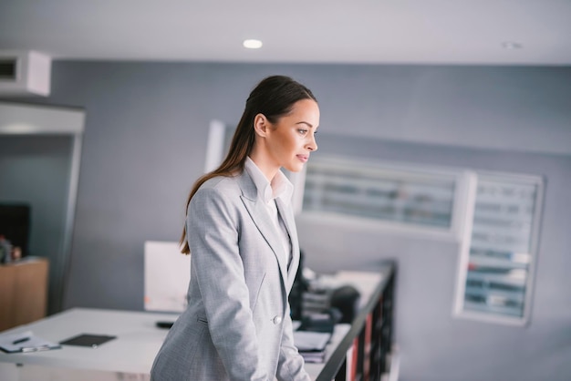 A dedicated businesswoman standing at office and thinking of next business move