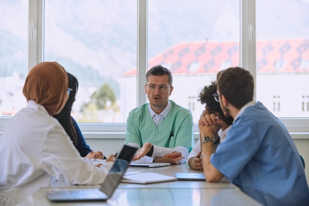 A dedicated group of doctors and medical nurses attentively listens to their colleagues work plan in