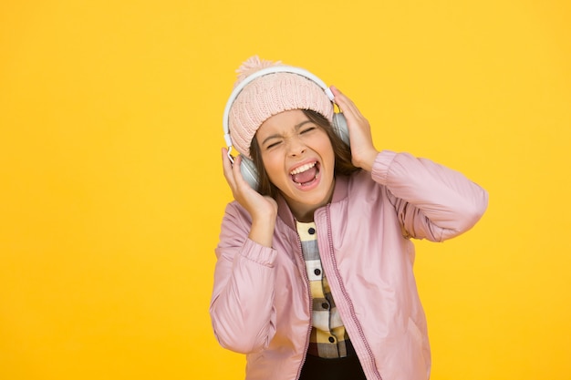 Dedicated to singing. Small singer yellow background. Happy girl enjoy singing to music. Singing lesson. Vocal exercises. Learn to sing. Music school. Her singing voice is really lovely.