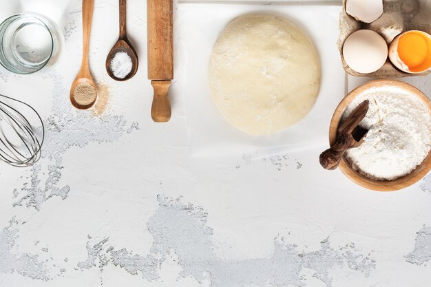 Deeg en ingrediënten voor de bereiding van pasta, deeg, eieren, bloem, water en zout op een lichte rustieke oude tafel