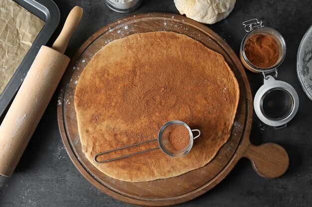 Foto deeg met kaneelpoeder op een houten bord