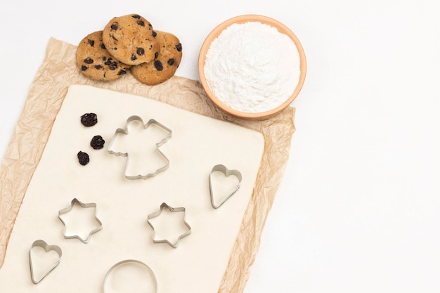 Foto deeg voor het bakken van koekjes op papier cookie cutter vormen meel in de schaal en kant-en-klare koekjes