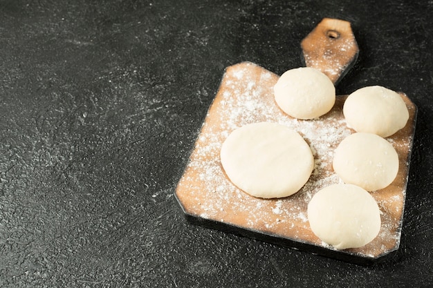 Deegballen op een houten plaat op de zwarte achtergrond