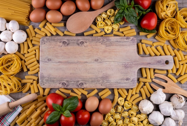 Deegwaren, groenten, eieren, op houten raad, ingrediënten voor Italiaans restaurant