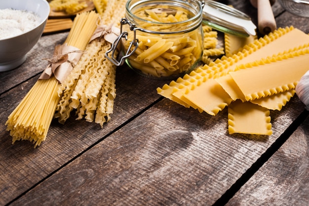 Deegwarenspaghetti met bloem, ei op oude houten achtergrond