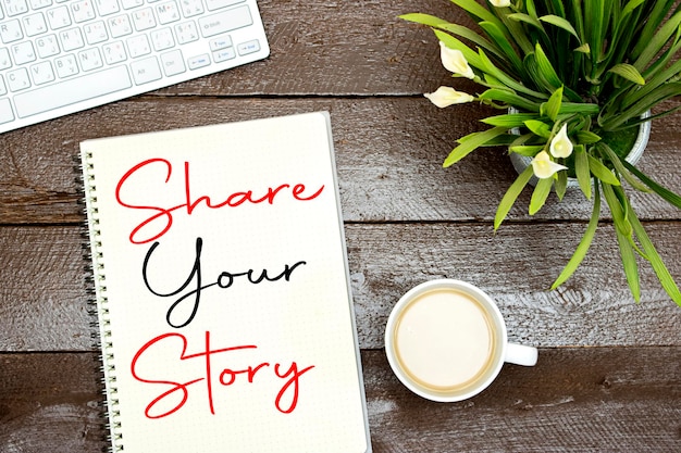 Deel je verhaalconcept op een notitieboek met een kop koffie en een toetsenbord lelies bloemen
