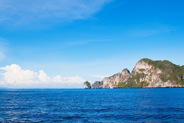 Deep blue Andaman sea view with cloudy sky and rock island on horizon