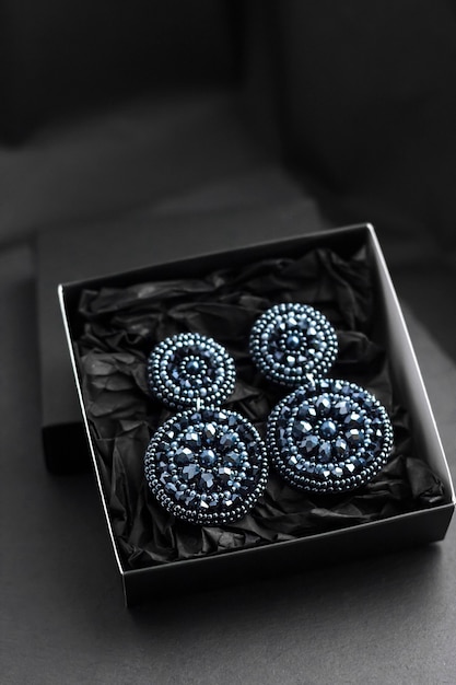 Deep blue beads embroidered earrings on black surface