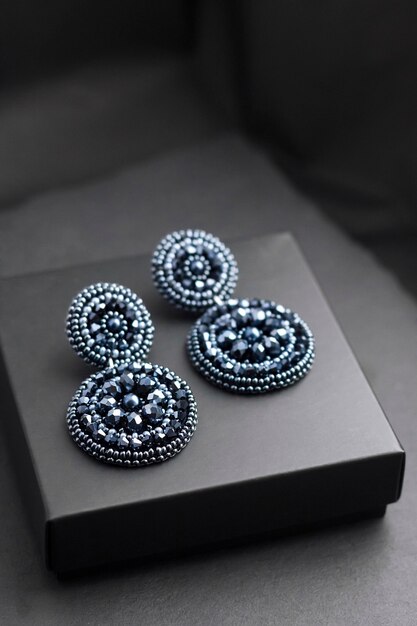 Deep blue beads embroidered earrings on black surface
