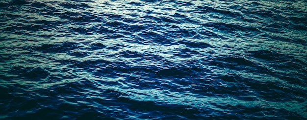 自然と環境デザインとしての深い青色の海の水のテクスチャ暗い海の波の背景
