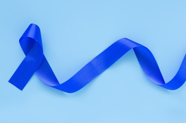 Deep blue ribbon curl on white fabric with copy space