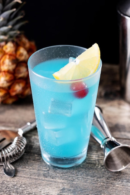 Cocktail martini di mare blu profondo sulla tavola di legno