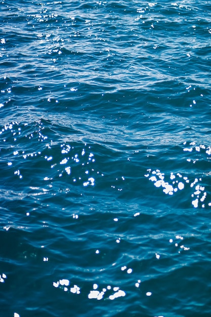 自然と環境デザインとしての深い青色の海の水のテクスチャ暗い海の波の背景