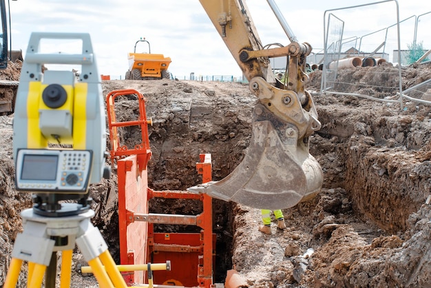 Deep drainage excavation works with red trench support box installed into  trench and yellow total