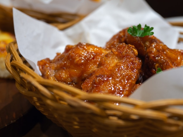 Pollo fritto nel grasso bollente in un cestino con prezzemolo