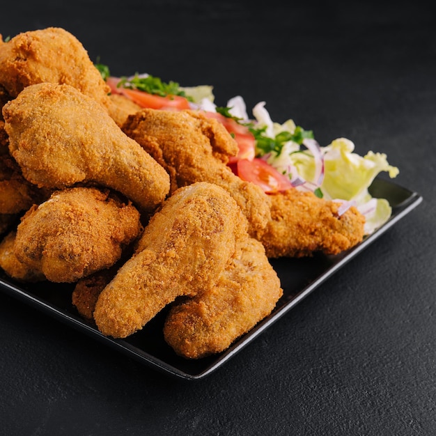 Photo deep fried chicken on black plate