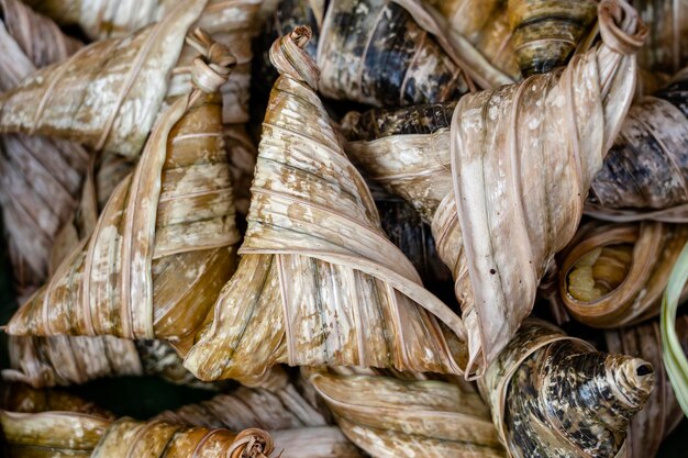 Deep fried chicken wrapped in green pandan leaves at street food market in Thailand Thai food concept