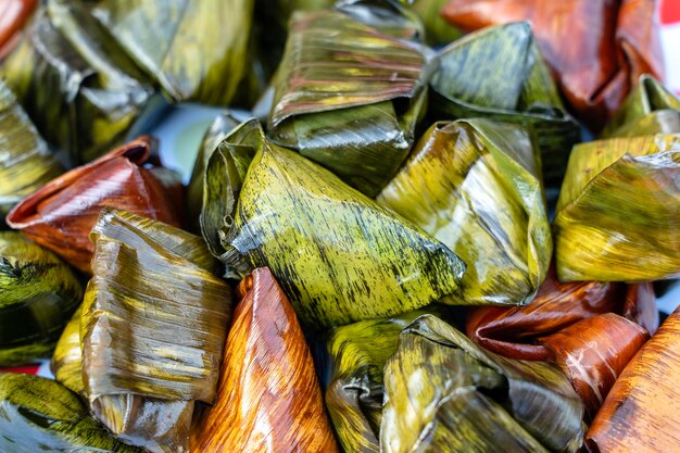 Deep fried chicken wrapped in green pandan leaves at street food market in Thailand Thai food concept