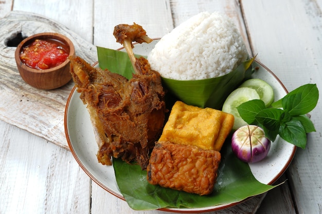 deep fried duck served with rice, vegetables and sambal (nasi bebek )-indonesian food style.