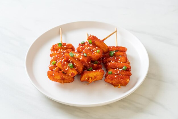 Deep fried Korean rice cake Tteokbokki skewered with spicy sauce