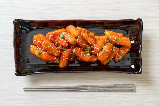 Foto torta di riso coreana fritta nel grasso bollente (tteokbokki) con salsa piccante - stile di cibo coreano