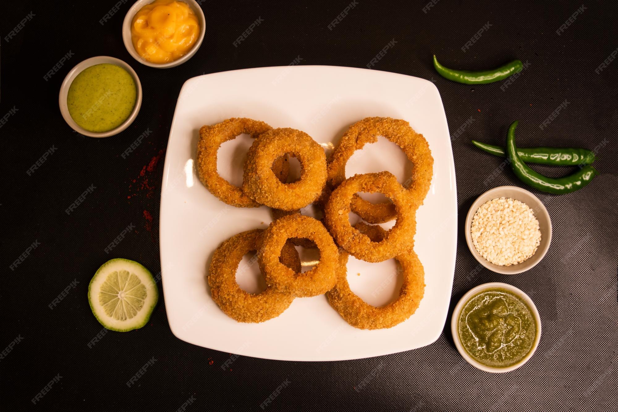 Premium Photo Deep fried onion rings with lime dip and sauce served