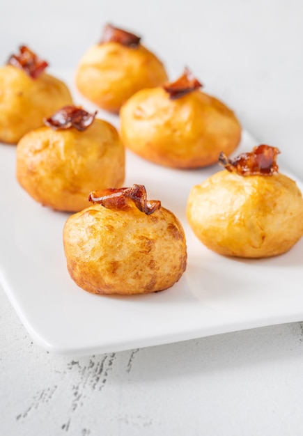 Deep fried potato parmesan balls with glazed bacon