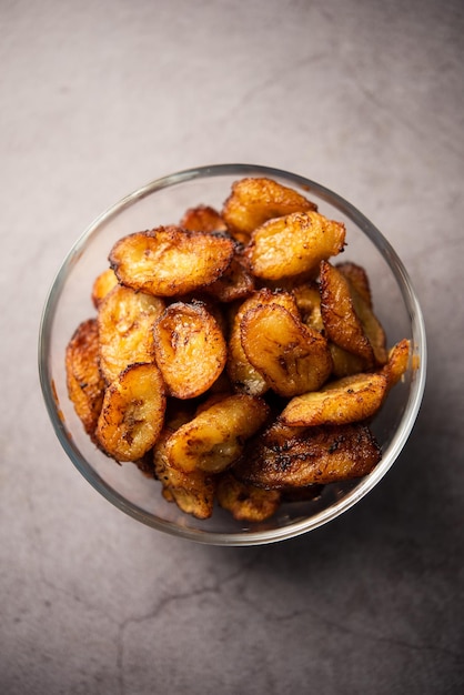 Deep fried ripe plantain slices or pake kele fried chips in a bowl