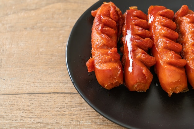 deep fried sausage skewer on black plate