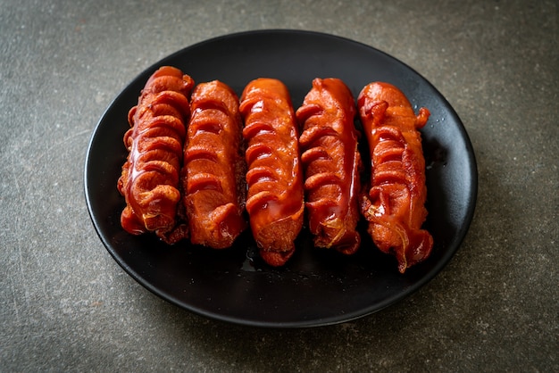 deep fried sausage skewer on black plate