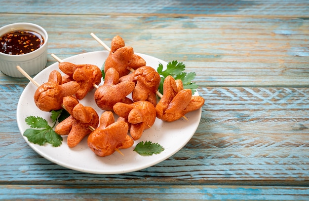 deep fried sausage skewer with dipping sauce