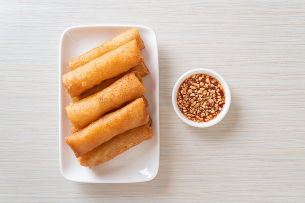 deep fried spring roll with sauce on white plate