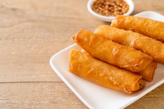 deep fried spring roll with sauce on white plate