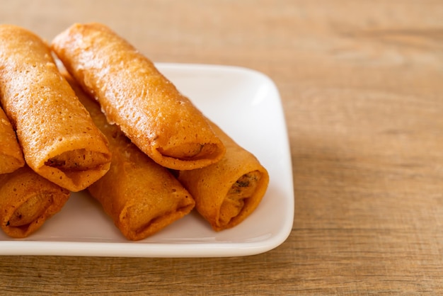 deep fried spring roll with sauce on white plate