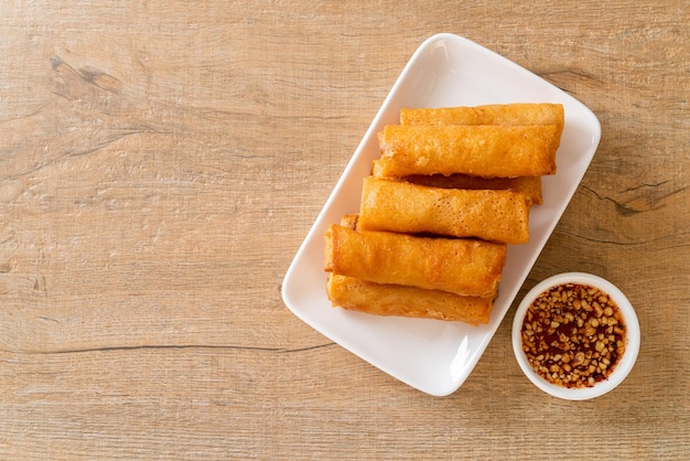 deep fried spring roll with sauce on white plate