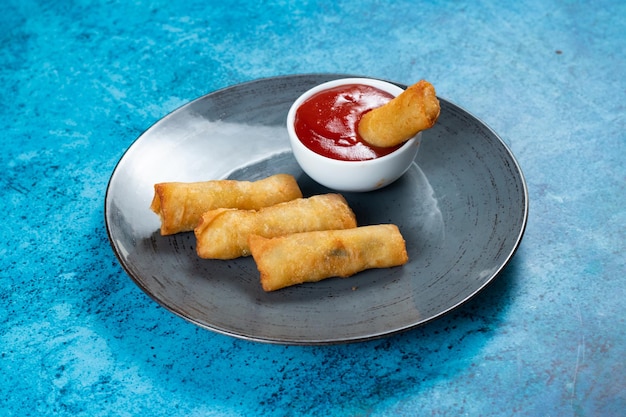 Deep fried spring roll with tomato sauce and mayo dip served in dish isolated on table top view of fastfood