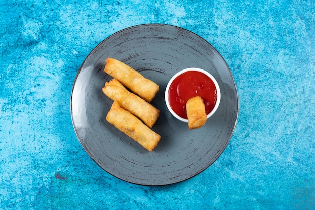 Deep fried spring roll with tomato sauce and mayo dip served in dish isolated on table top view of fastfood