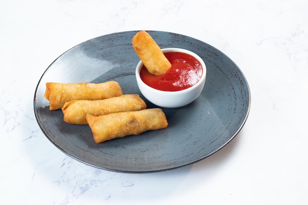 Photo deep fried spring roll with tomato sauce and mayo dip served in dish isolated on table top view of fastfood