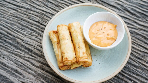 Deep fried spring roll on a wooden table.