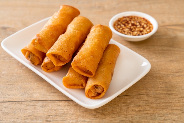 deep fried spring rolls with sauce on white plate