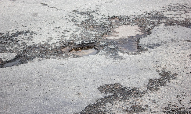 도로의 깊은 구덩이 손상된 아스팔트도로의 움푹 들어간 곳의 웅덩이 손상된 고속도로아스팔트의 구덩이가 파괴된 도로 파괴된 노면