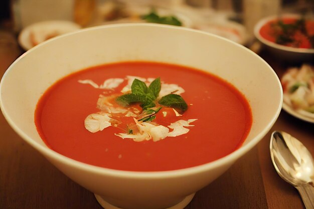 Deep plates of rich thick gazpacho soup with sour cream and herbs