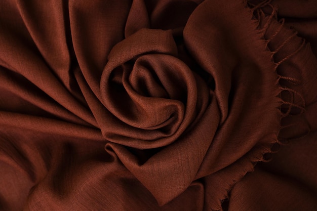 Deep rich brown colored cashmere scarf Folded and flowing background Decoration design Soft focus Luxury fashion concept Dark chocloate backdrop with curves Smooth elegant wrinkled fabric