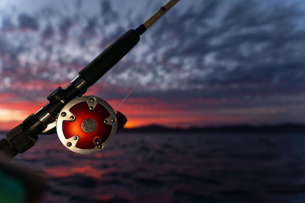 Deep sea fishing reel on a boat during sunrise