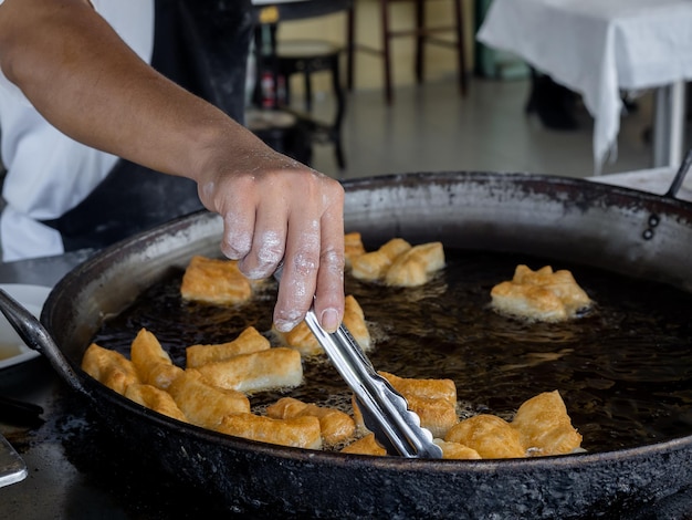 揚げ生地スティックまたはタイのパトンコ タイのアジアの有名な屋台の食べ物 中国のドーナツ 小麦粉から作られ、熱い油でフライパンで調理された伝統的な黄色のサクサクしたスナック