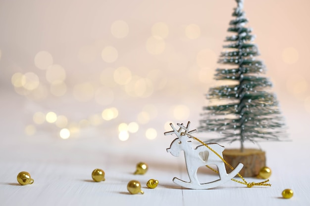 鹿の置物、クリスマスツリー、テーブルの上の金色のボール。クリスマスの飾り