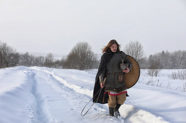 Defender the young warrior in mail armor armed with a sword and an ax