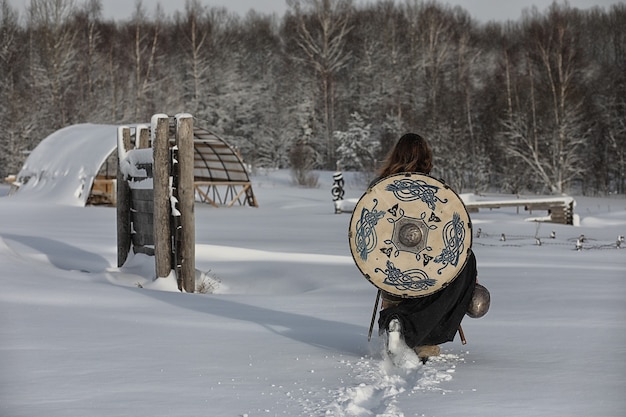 Defender the young warrior in mail armor armed with a sword and an ax