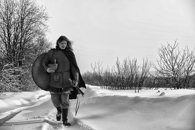 Defender the young warrior in mail armor armed with a sword and an ax